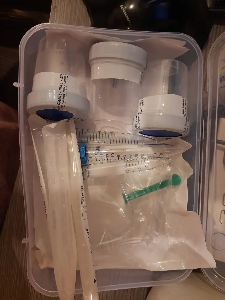 Syringe kit containing various components for assisted baby feeding, including syringes and collection cups.