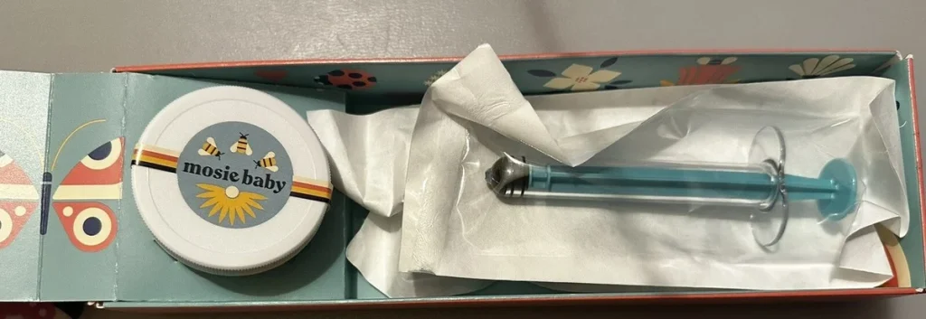 Mosie Baby at-home insemination kit featuring a syringe and a container, presented in a decorative box.